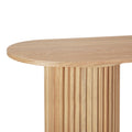 Close-up of oval oak console tabletop edge and fluted cylindrical column base, natural wood grain, white background