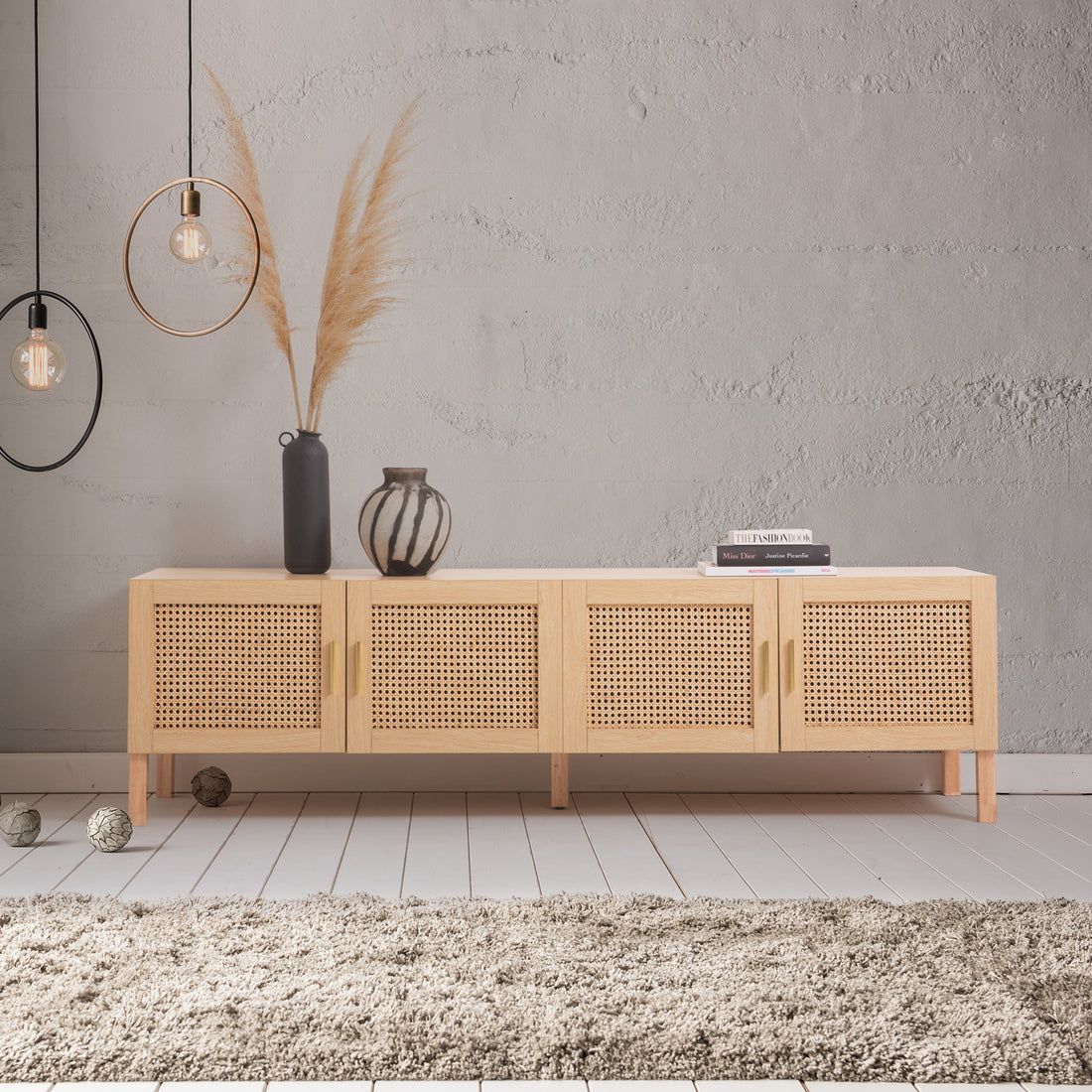 Oak and rattan TV unit front view on white four cane-weave doors with gold bar handles on light wood legs