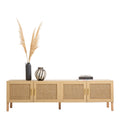 Oak and rattan TV unit on white with pampas grass tall dark vase striped vase and stacked fashion books on top