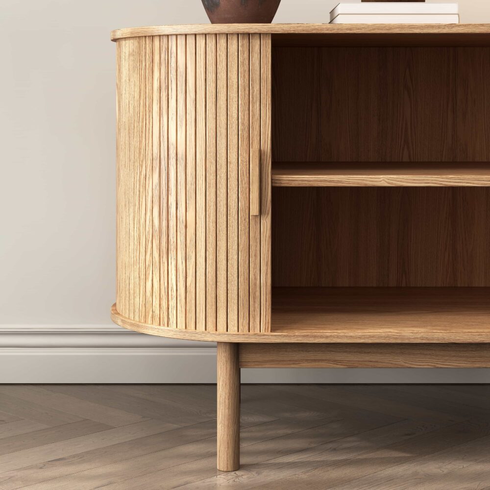 Close-up of oak reeded sideboard rounded end panel and open interior showing two shelves, tapered leg on herringbone floor