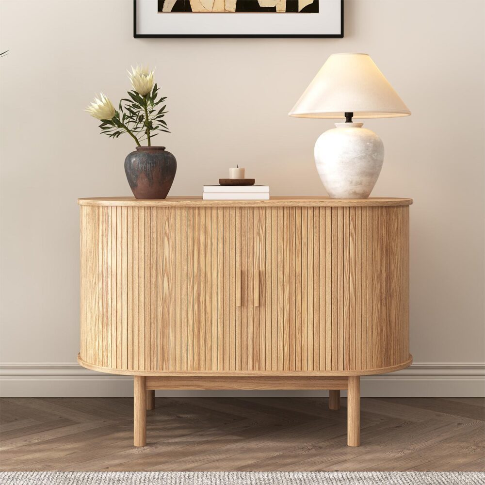 Natural oak reeded sideboard in hallway setting, two large reeded doors, vase with flowers and table lamp on top