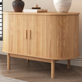 Natural oak sideboard with rounded ends, vertical reeded front panels on two doors with cutout handles, on tapered legs
