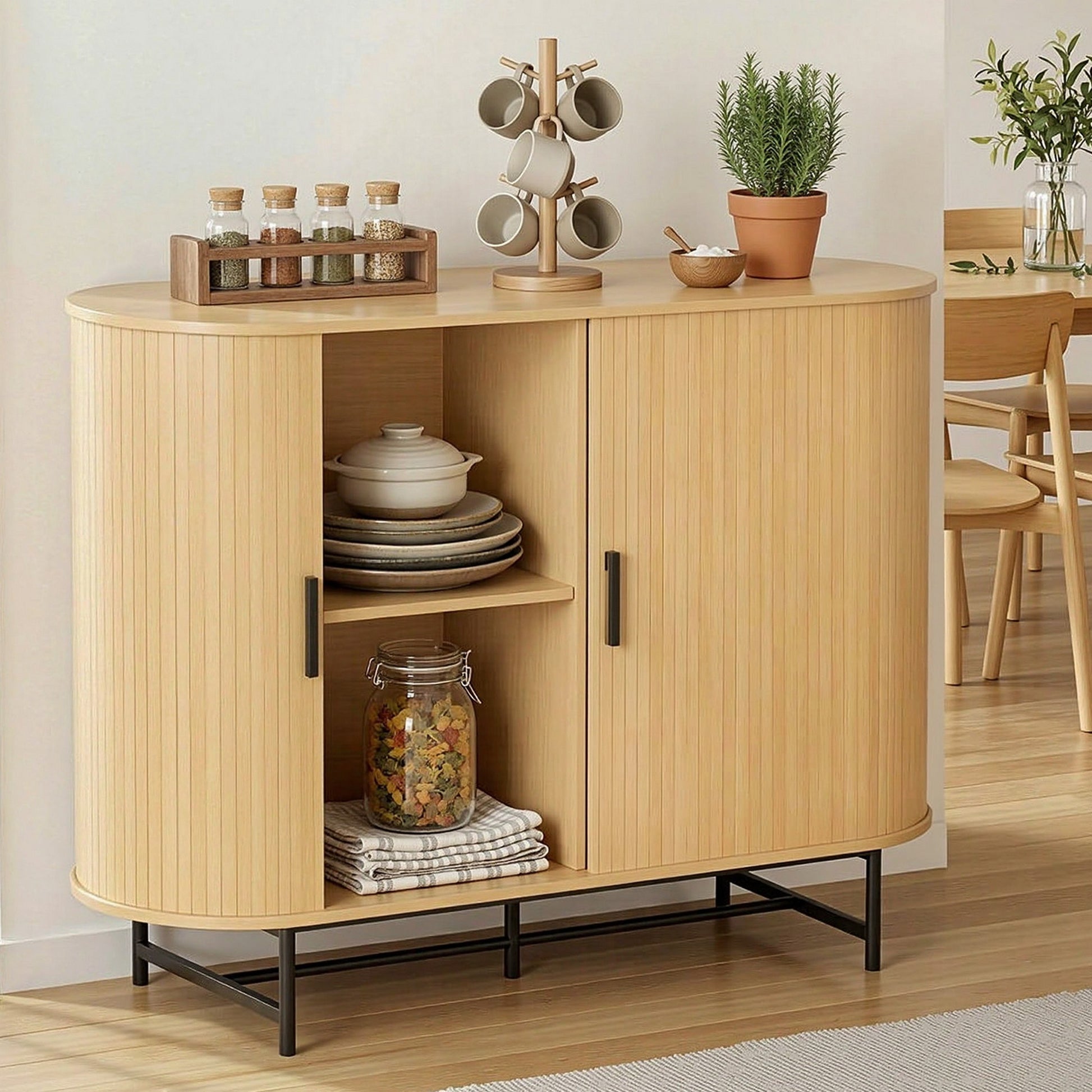 Oak sideboard with one door open displaying dishes and kitchenware on shelves, styled in a dining room setting