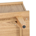 Close-up of oak wooden leg with black rubber protective foot on TV stand