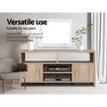 Oak TV stand 140cm versatile use lifestyle in grey room with grey armchair vases and disc player on shelves