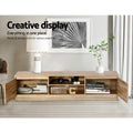 Oak TV stand 160cm creative display lifestyle with both doors open books camera and woven items