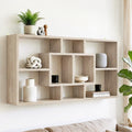 Natural oak wall-mounted display shelf with asymmetric grid compartments, styled with plants, ornaments and books