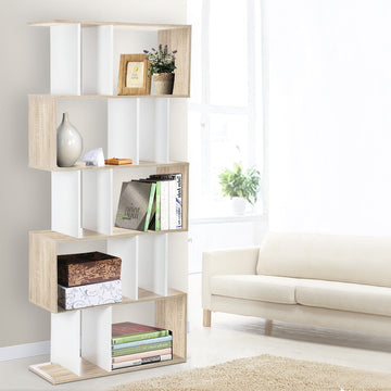 Oak and white S-shaped 5-tier display shelf in living room styled with books, vase and plant beside cream sofa