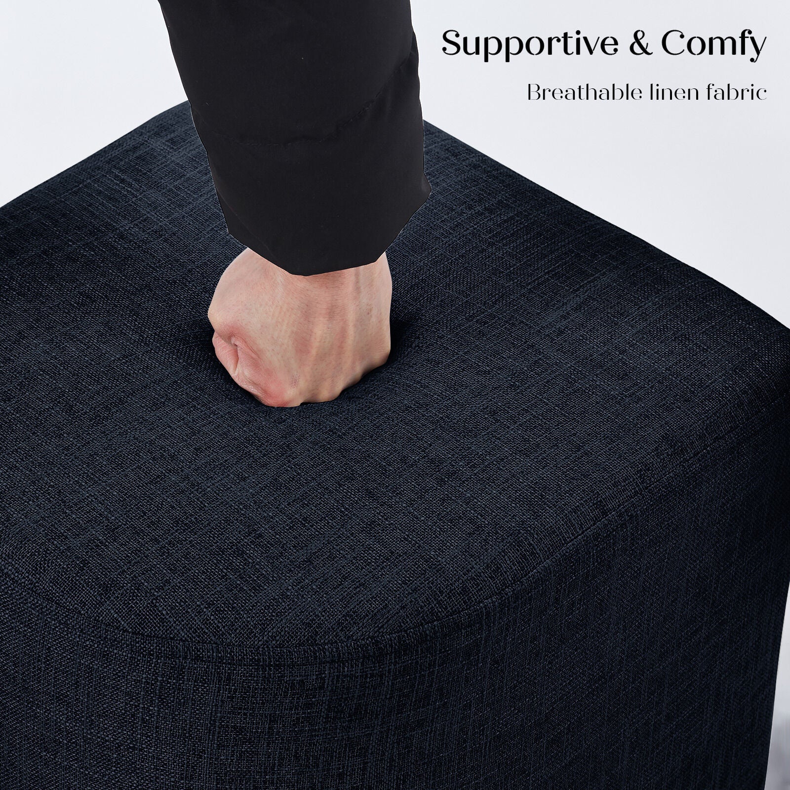A fist pressing down into the surface of a dark navy linen ottoman top demonstrating cushion firmness