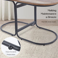Close-up of the dark iron oval base frame of a coffee table on a light rug with a callout showing rubber floor scratch
