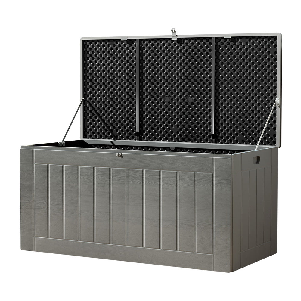 Grey outdoor plastic deck box with lid fully open, three-quarter angle view on white background
