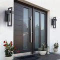 Two black rectangular framed wall lights flanking a dark grey entry door with glass sidelites, flower pots in foreground