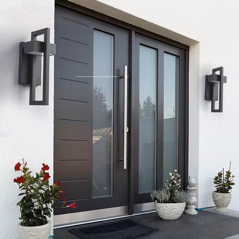 Two black rectangular framed wall lights flanking a dark grey entry door with glass sidelites, flower pots in foreground