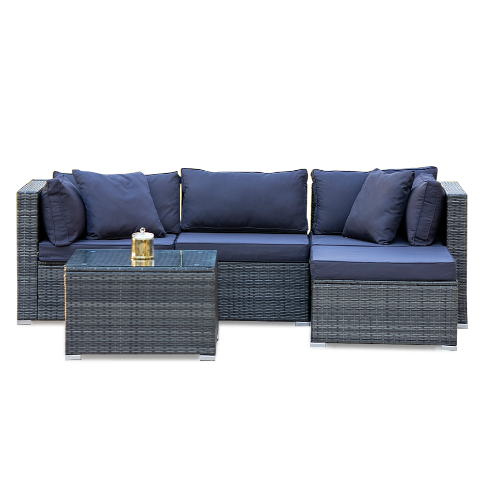 4-piece grey wicker outdoor sofa set with navy cushions and glass coffee table in L-shape configuration on white background