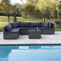 6-piece dark grey wicker outdoor sectional sofa set with navy cushions arranged beside swimming pool with trees
