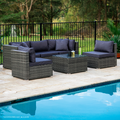5-piece grey wicker outdoor sofa set with navy cushions beside pool on stone patio seen from angle view, trees in background