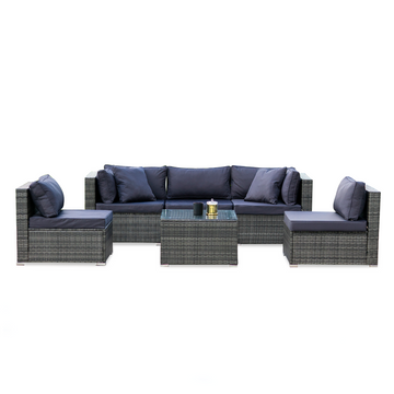 5-piece grey wicker outdoor sofa set with navy cushions in straight configuration with glass coffee table on white background