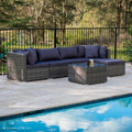 5-piece dark grey wicker outdoor sofa set with navy cushions in front-angle view beside pool on stone patio