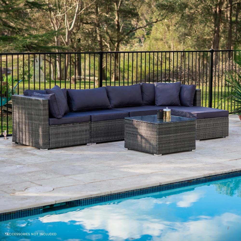 5-piece dark grey wicker outdoor sofa set with navy cushions in front-angle view beside pool on stone patio