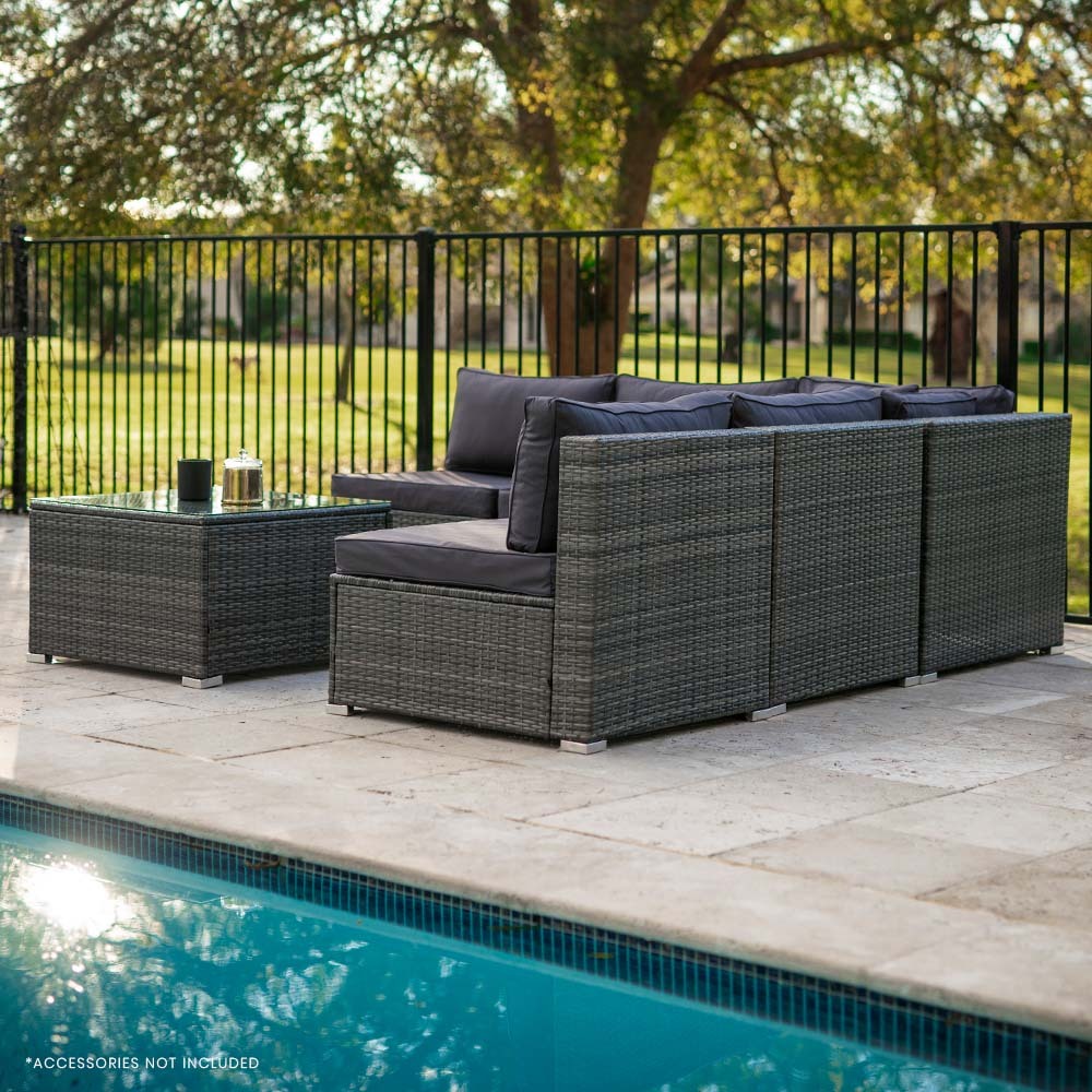 Rear view of 5-piece dark grey wicker outdoor sofa set with dark grey cushions beside pool on stone patio
