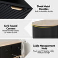 Oval oak-top black TV unit sleek metal handles safe rounded corners and cable management hole close-up details