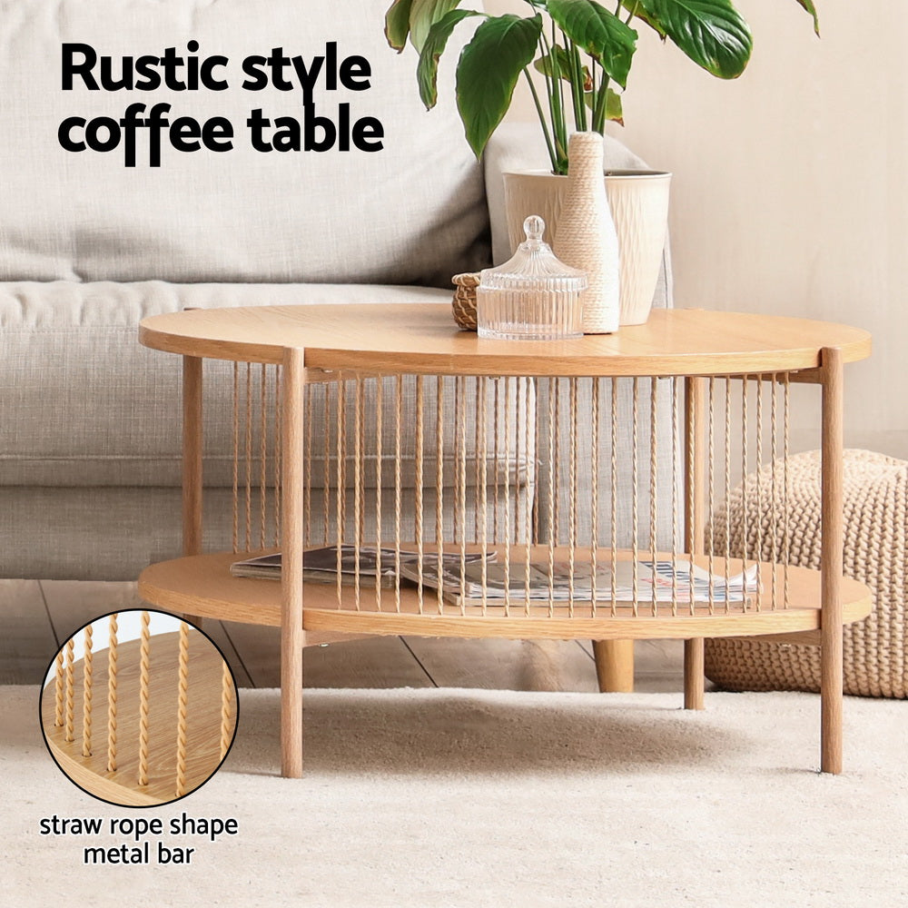 Oval two-tier natural oak coffee table in a living room with a glass jar and magazines on surfaces, close-up of twisted rope