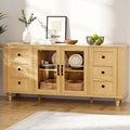 Pine sideboard in room with glass doors open showing dishes and baskets inside, vase, frame and fruit bowl on top