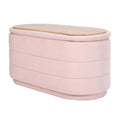 Oval pink fabric storage ottoman with horizontal channel stitching and natural wood grain lid on white background
