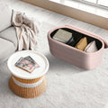 Pink storage ottoman open with lid off showing black interior holding an Art and Craft box and cushion in living room