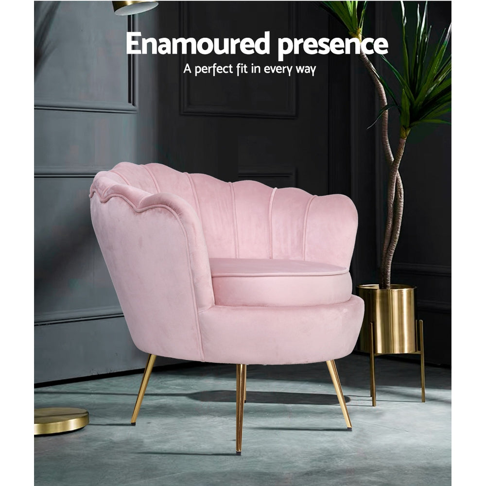 Pink velvet scallop shell armchair with gold legs in dark moody room beside tall plant in gold pot, Enamoured presence text