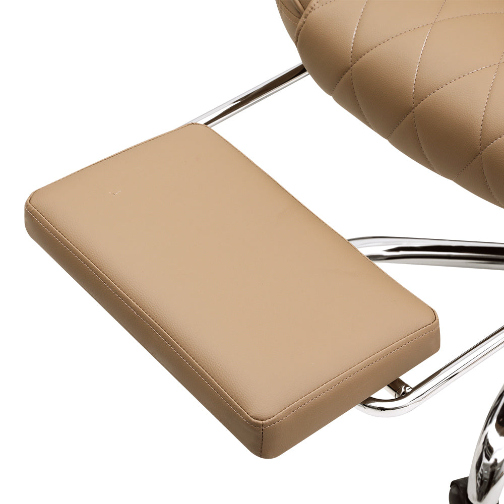 Close-up of tan PU leather retractable footrest pad with chrome support arm and diamond-stitch seat visible in background