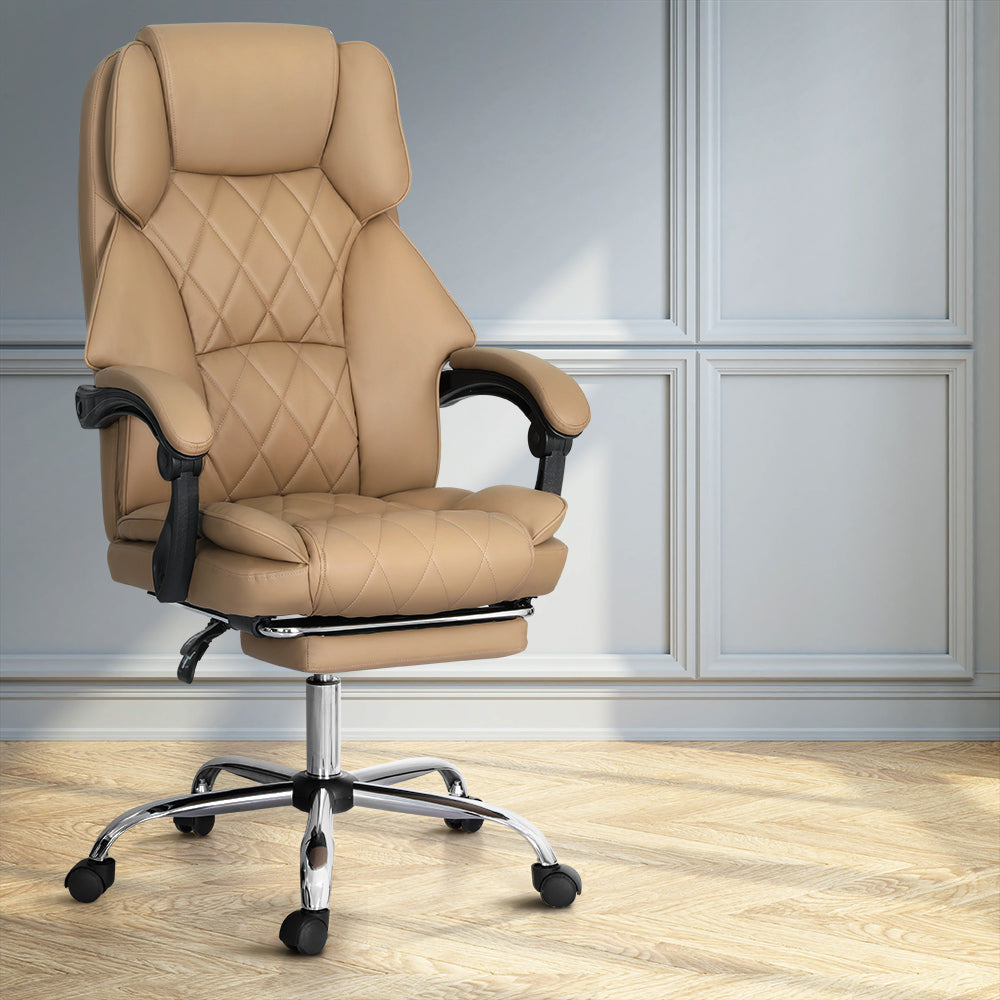 Tan PU leather diamond-stitch high-back executive chair with chrome base in lifestyle room with grey panelled walls