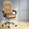 Tan PU leather diamond-stitch high-back executive chair with chrome base in lifestyle room with grey panelled walls