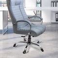 Grey PU tufted high-back executive chair with chrome padded armrests and five-star base in modern office setting