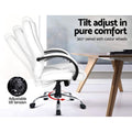 White PU executive chair side view showing tilt adjustment range and 360-degree swivel with castor wheels next to wooden desk
