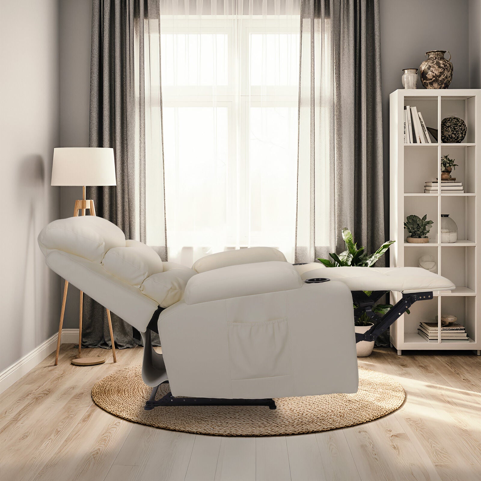 Cream PU leather recliner fully reclined with footrest extended, side view in living room with bookshelf and floor lamp