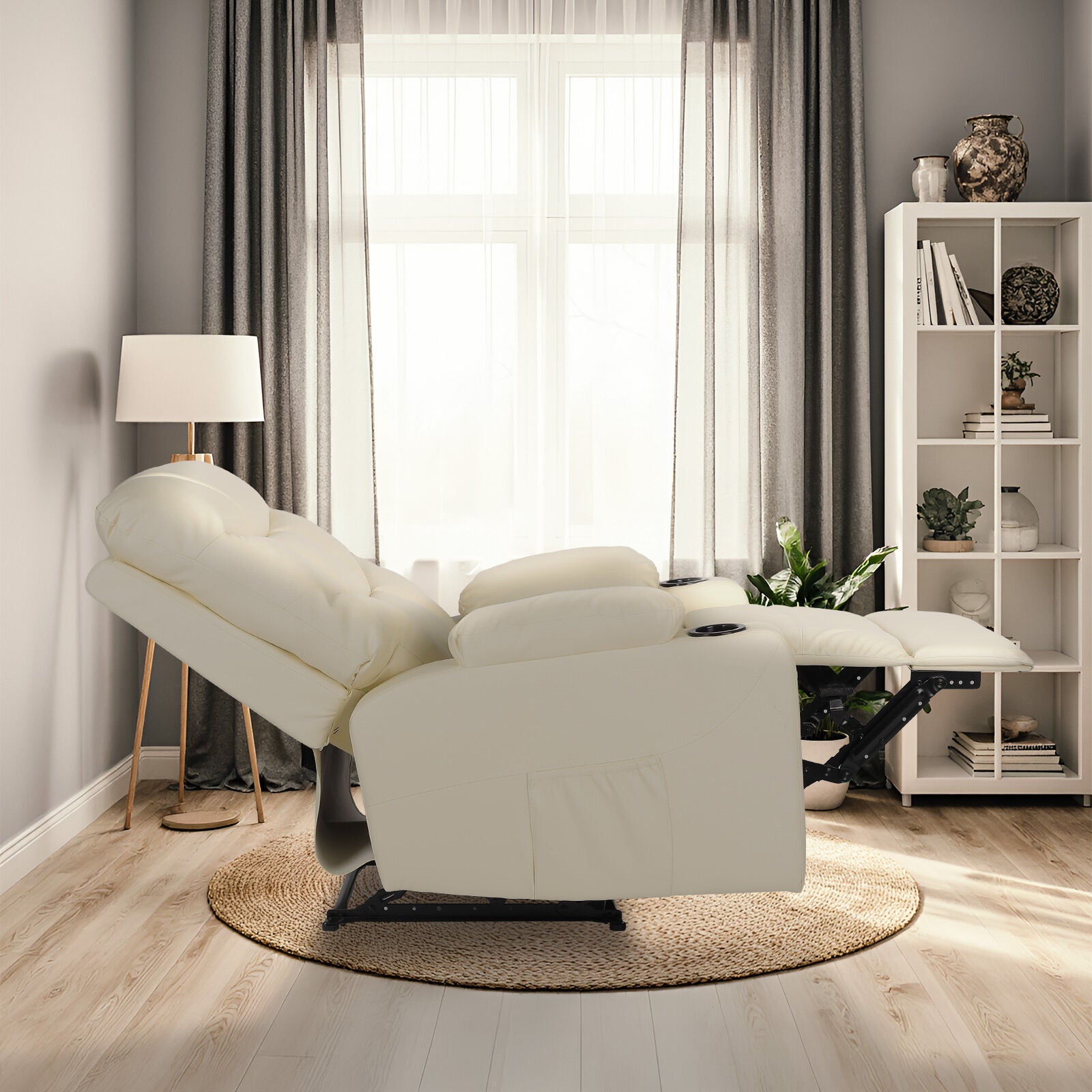 Cream tufted PU recliner fully reclined with footrest extended, side view in living room with bookshelf and floor lamp