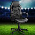 Black and grey PU mesh racing-style gaming chair angle view on stadium football pitch lifestyle background