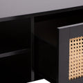 Close-up detail of black coffee table showing rattan weave door panel texture and open shelf sections