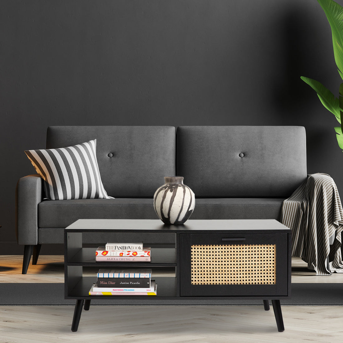 Black coffee table with rattan weave sliding door on right, open double shelf on left and black tapered legs, white background