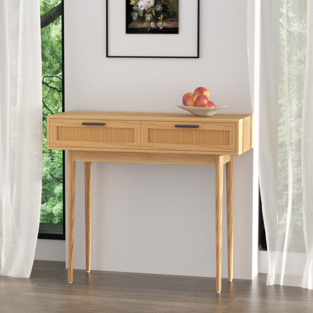 Oak console table with two rattan-weave drawers and black bar handles on tapered legs, styled with fruit bowl in room