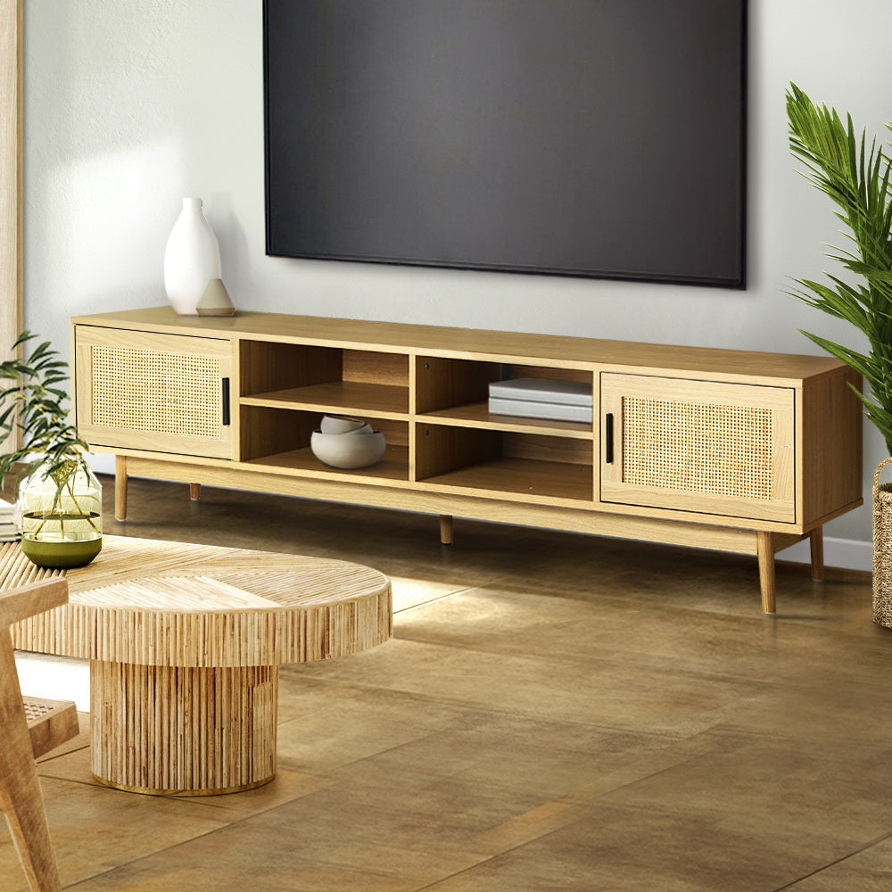 Rattan TV stand 180cm in living room below wall-mounted TV with rattan round coffee table and tropical plants