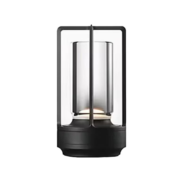 Two black retro lantern LED lamps glowing amber on dark coffee table books against white sheer curtain backdrop