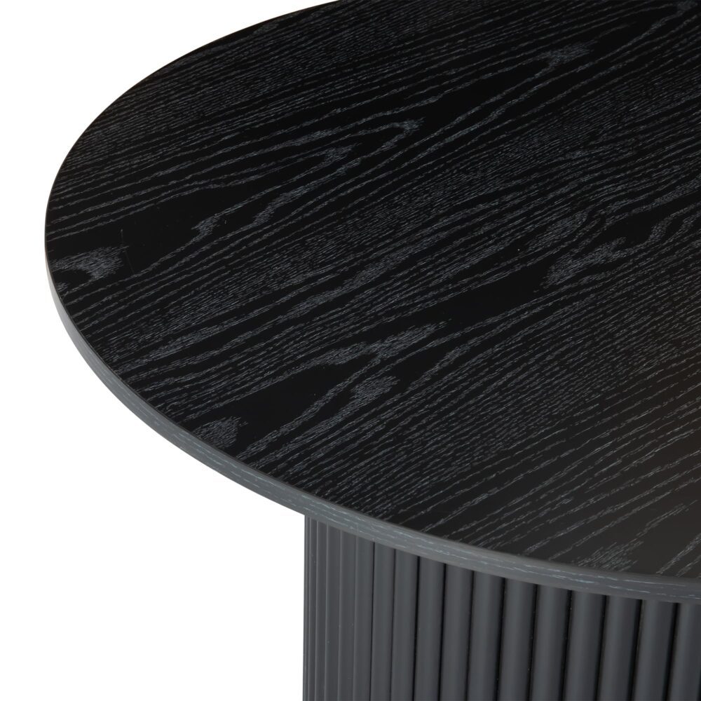 Close-up side-angle of black round coffee table showing wood grain texture of top surface and fluted base edge