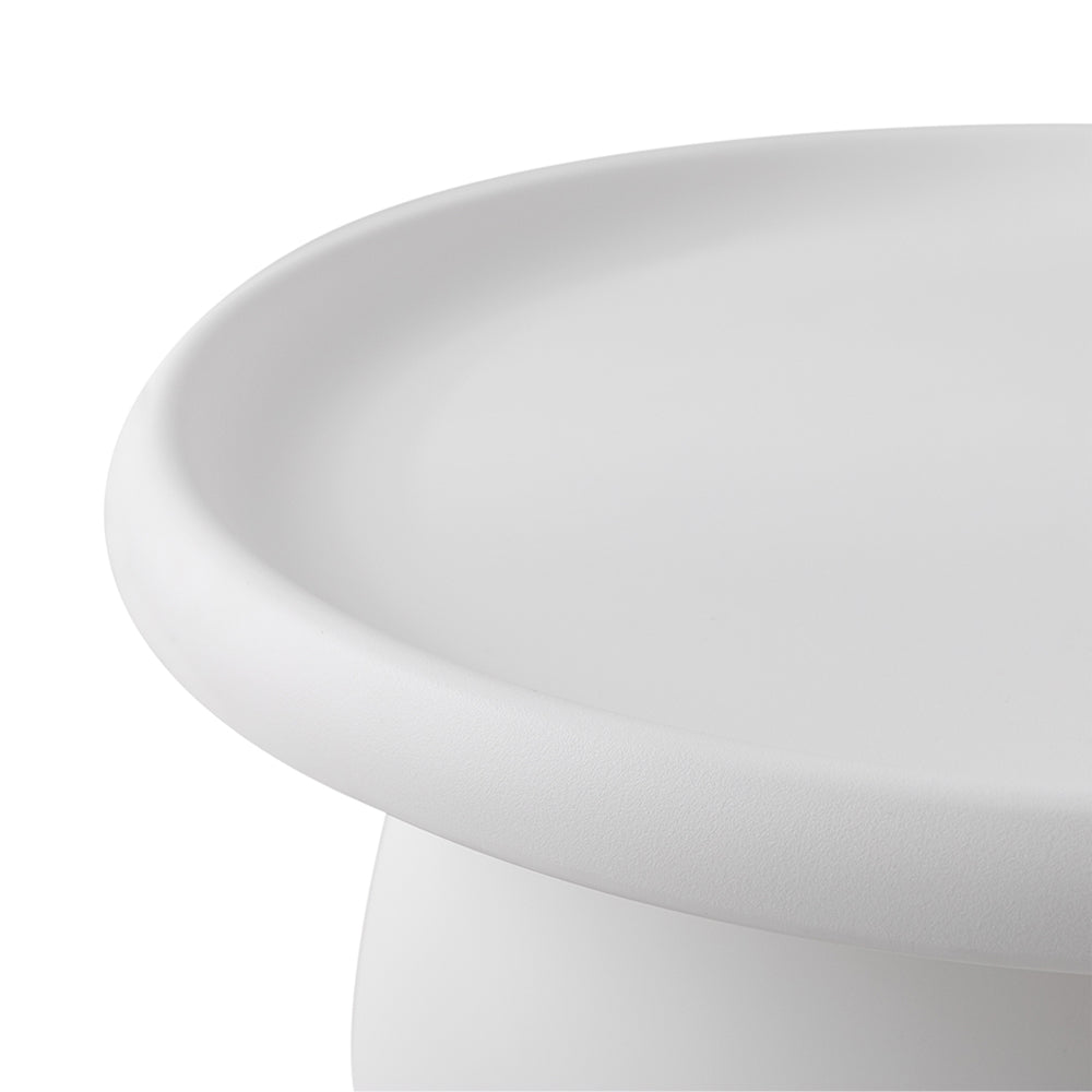 Close-up of the curved rim and matte white tray top surface of a round coffee table on white background