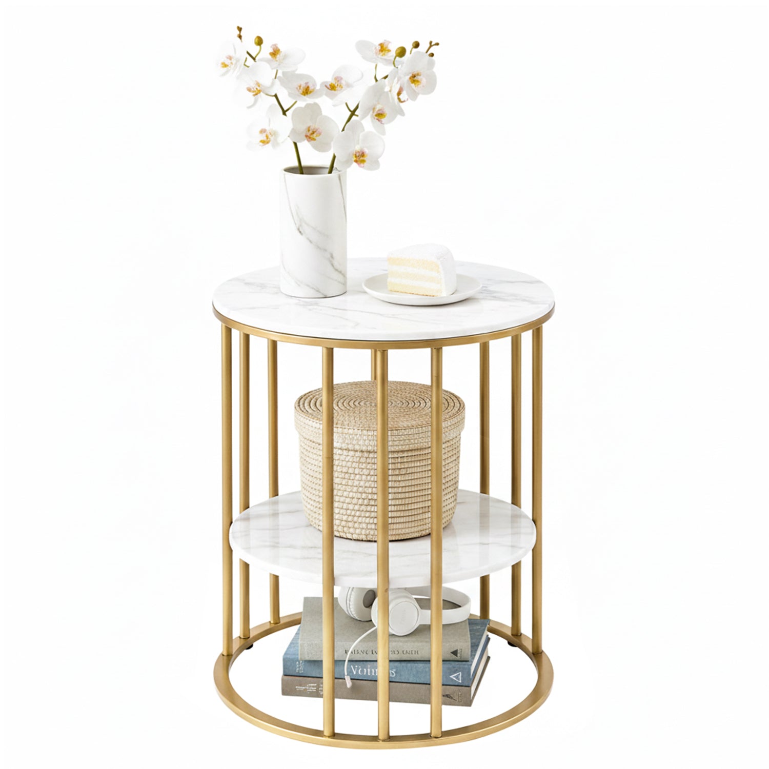 Round marble top side table with gold frame, orchids and cake on top, rattan basket on mid shelf, books on bottom