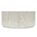 Top-down view of round coffee table surface covered in mother of pearl mosaic tiles arranged in four alternating direction