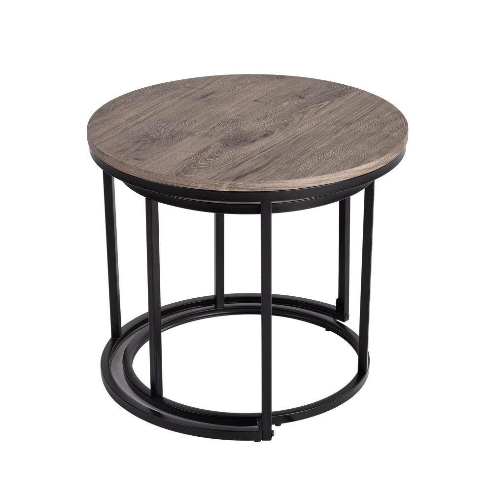 Large round coffee table with grey-tone wood top and black metal base with smaller table nested inside, white background
