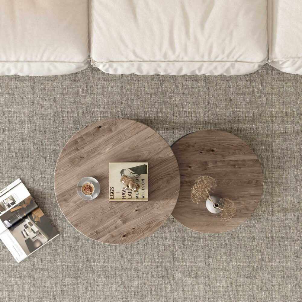Top-down view of two round nesting coffee tables with walnut wood grain tops on grey carpet near sofa
