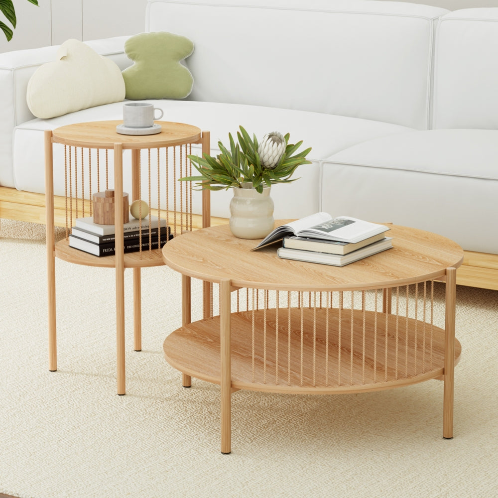 Round oak two-tier coffee table and matching side table with a vase of flowers and books in front of a white sofa on a cream